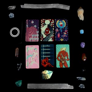 May include: A tarot card spread with nine cards laid out in a grid pattern. The cards are illustrated with colorful, fantastical imagery. The cards are surrounded by various crystals and stones.