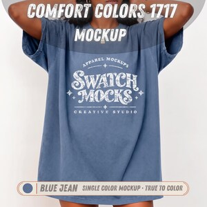 May include: A blue jean colored t-shirt featuring the white text COMFORT COLORS 1717 MOCKUP at the top and APPAREL MOCKUPS SWATCH MOCKS CREATIVE STUDIO in the center. The shirt has short sleeves and a loose fit with a distressed graphic design.