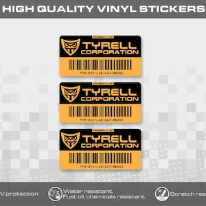 Könnte beinhalten: Drei rechteckige Vinylaufkleber in Schwarz und Orange. Jeder Aufkleber zeigt ein Eulenlogo, den Text PROPERTY OF TYRELL CORPORATION, einen Strichcode und die eindeutigen Seriennummern TYR-BIO-LAB-A17-88201, 88202 und 88203.