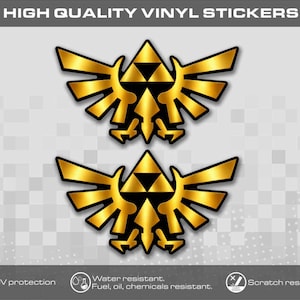 May include: Two gold-coloured vinyl stickers featuring the Triforce emblem with wings. The text at the top reads HIGH QUALITY VINYL STICKERS. Bottom icons indicate UV protection, water, fuel, oil, and chemical resistance, and scratch resistance.