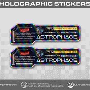 Könnte beinhalten: Zwei rechteckige holografische Aufkleber mit abgerundeten Ecken, schwarzem Hintergrund und regenbogenfarbenen metallischen Rändern. Der Text lautet WARNING ASTROPHAGE CONTAINMENT UNIT EXTREME ENERGY DENSITY DO NOT EXPOSE TO ATMOSPHERE AUTHORIZED HANDLING ONLY PHM AP-5530-TAU-CETI POWERED BY ASTROPHAGE.