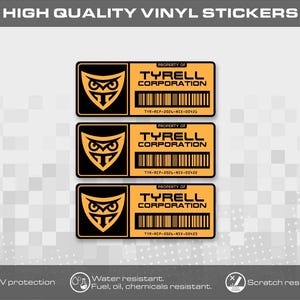 Könnte beinhalten: Drei rechteckige Vinyl-Aufkleber mit einem schwarz-orangen Eulen-Logo auf der linken Seite und dem Text Property of Tyrell Corporation mit einem Strichcode und einer Seriennummer auf der rechten Seite. Die Aufkleber sind orange und schwarz.