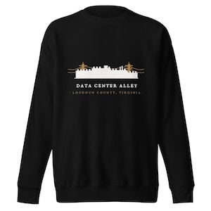 May include: A black crewneck sweatshirt featuring a white graphic of a building silhouette with brown power lines. The text reads DATA CENTER ALLEY and LOUDOUN COUNTY, VIRGINIA in white and brown lettering centered on the chest area of the garment.