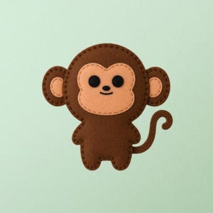 Pode incluir: Uma aplicação de feltro castanha em forma de macaco com um rosto cor de pêssego claro, duas orelhas redondas e uma cauda enrolada. O macaco apresenta contornos cosidos em castanho escuro, dois olhos circulares pretos e uma boca pequena.