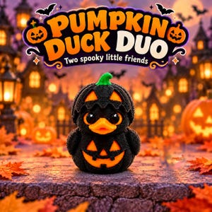 May include: A black and orange duck figurine wearing a pumpkin-shaped shell with a green stem. The duck has large black eyes and an orange beak. Above the duck, text reads PUMPKIN DUCK DUO and Two spooky little friends in a decorative banner.