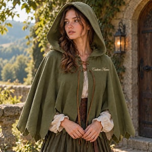 Una capa verde con capucha y lazos delanteros, una prenda de estilo medieval adecuada para juegos de rol.