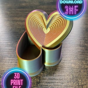 May include: A 3D printed heart-shaped box with a gold and iridescent finish. The box is open and the lid is shaped like a heart. The box is on a wooden surface. The text "INSTANT DOWNLOAD .3MF" is in a neon pink circle. The text "3D PRINT FILE" is in a neon pink circle.