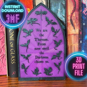 May include: A purple, arched 3D-printed plaque with dragon silhouettes and the text "We are the Thirteen. From now until the Darkness claims us." The plaque is surrounded by a black frame and is displayed in front of a bookshelf.