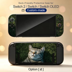 Può includere: Una custodia protettiva per console Switch 2, Switch e Switch OLED. La parte anteriore presenta un motivo a erba verde, mentre il retro mostra un gatto grigio tigrato che riposa sull'erba. Il testo recita: Dock-Friendly Protective Case for Switch 2 / Switch / Switch OLED, Custom-made, Option [ d ].