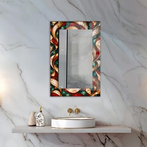 Op de afbeelding: Een rechthoekige wandspiegel met een decoratieve rand in een wervelend glas-in-loodstijl patroon in tinten dieprood, smaragdgroen en goud. Het frame toont een complex, onderling verbonden ontwerp met gestructureerde, schubachtige details.