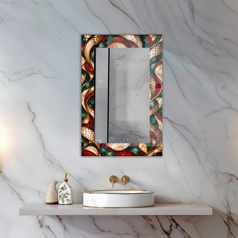 Op de afbeelding: Een rechthoekige wandspiegel met een decoratieve rand in een wervelend glas-in-loodstijl patroon in tinten dieprood, smaragdgroen en goud. Het frame toont een complex, onderling verbonden ontwerp met gestructureerde, schubachtige details.