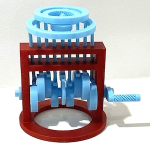 May include: A mechanical model featuring a red frame with a circular base and a hand crank. The internal mechanism consists of light blue crankshaft components and vertical rods that connect to light blue rings positioned at the top of the structure.
