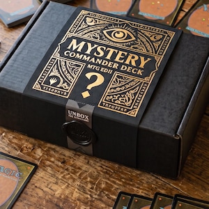 Könnte beinhalten: Eine schwarze Pappschachtel mit der Aufschrift Mystery Commander Deck MTG EDH und goldenem Grafikdesign, dazu eine Packung mit 100 transparenten Kartenhüllen und eine pergamentartige Karte mit Inhaltsangabe inklusive 100 Karten und Bonus-Token.