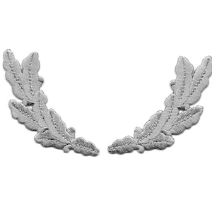 May include: Two silver embroidered leaf appliques arranged in a semi-circular design. The leaves have detailed stitching and are set against a white background. Ideal for embellishing clothing or crafts.