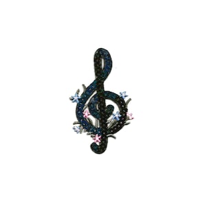 May include: A black treble clef with blue and pink flowers around it. The flowers are embroidered with sequins.
