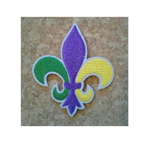May include: A purple, green, and yellow embroidered fleur-de-lis patch.