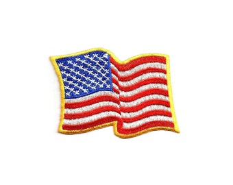 May include: A small embroidered American flag patch with a yellow border. The flag is waving in the wind.