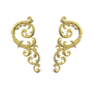 May include: Two gold glitter decorative embellishments with a swirling, floral design.