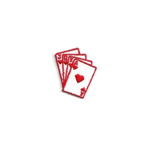 May include: A red embroidered patch of a hand of playing cards, including a Jack, Queen, King, and Ace of Hearts.