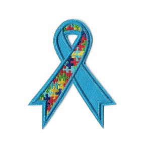 May include: A light blue embroidered ribbon patch with a puzzle piece design in the center. The ribbon is a symbol of autism awareness, with a light blue border and a colorful puzzle piece pattern.