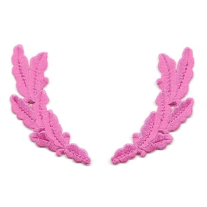 May include: Two pink fabric laurel wreaths with detailed leaf designs.
