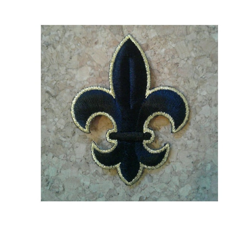 May include: Black embroidered fleur-de-lis patch with gold outline.