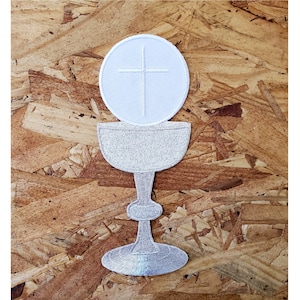 May include: White embroidered patch of a chalice with a host and cross on top. The chalice is a traditional symbol of the Eucharist.