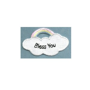 May include: White felt patch with a rainbow and the words "Bless You" embroidered in black thread.