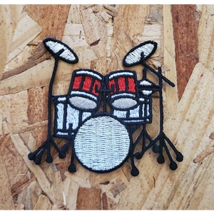 May include: Embroidered iron-on patch of a black and white drum set with red drums. The patch features a bass drum, two toms, and two cymbals.