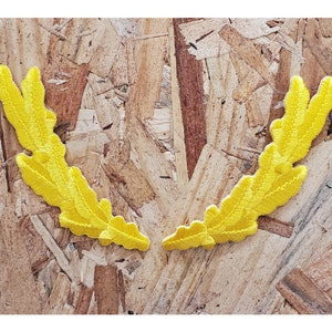 May include: Two yellow embroidered fabric patches in the shape of a laurel wreath.