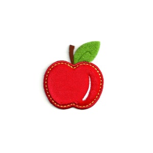 May include: A red felt apple with a green felt leaf and yellow stitching.