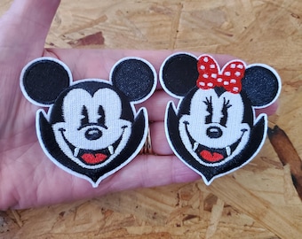 May include: Two embroidered patches featuring cartoon mouse characters. One patch depicts a male mouse with a black head and ears, white face, and red mouth. The other patch shows a female mouse with a red bow, black head and ears, white face, and red mouth.