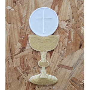 May include: A white embroidered patch of a chalice with a host and a cross on top. The chalice is gold and the host is white.