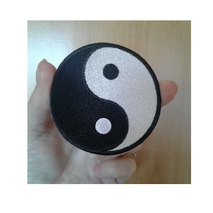 May include: A black and white yin yang symbol embroidered on a round patch.