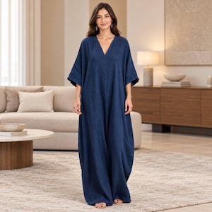Könnte beinhalten: Ein bodenlanges, marineblaues Kaftan-Kleid mit tiefem V-Ausschnitt, locker sitzenden, ellbogenlangen Ärmeln und einer entspannten, fließenden Silhouette. Das Kleidungsstück besteht aus einfarbigem Stoff mit dezenter Textur und reicht bis zu den Knöcheln.