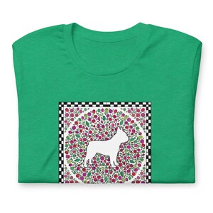 May include: A bright green t-shirt featuring a central square graphic. The graphic displays a white silhouette of a French Bulldog standing against a circular background filled with colorful red, pink, and green floral patterns, framed by a black and white checkerboard border.
