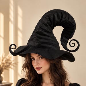 May include: A black witch hat featuring a tall, pointed, and curved crown with a spiraled tip. The hat has a wide, flexible brim with curled edges on both sides, constructed from a textured fabric with horizontal pleats throughout the design.