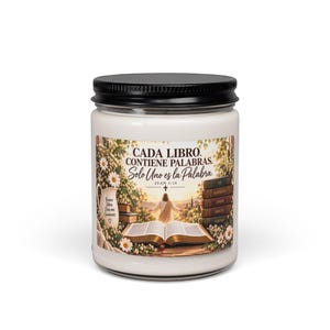 May include: A white candle in a clear glass jar with a black lid. The label features an open book, a figure standing in a landscape, and a stack of books with the text: CADA LIBRO. CONTIENE PALABRAS. Solo Uno es la Palabra. JUAN 1:14.