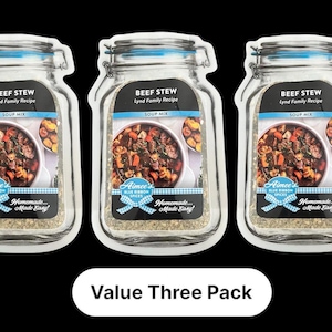 May include: Three jar-shaped packages of beef stew soup mix. Each package features a photo of the stew and the text "Beef Stew, Lynd Family Recipe, Soup Mix." The packages are labeled "Aimee's Blue Ribbon Spices" and "Homemade... Made Easy!" The text "Value Three Pack" is below.