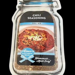 May include: Aimee's Blue Ribbon Spices Chili Seasoning mix in a clear glass jar with a blue lid. The jar is filled with a blend of spices. The label says "Chili Seasoning" and "Chili Mix". The label also features a photo of a bowl of chili with sour cream and shredded cheese. The label says "Homemade... Made Easy!"