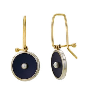 May include: A pair of gold earrings with black circular pendants and a small pearl in the center.
