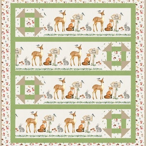 May include: A green and brown quilt with a repeating pattern of deer, foxes, bunnies, and mushrooms. The quilt has a white background with a green border and a brown border with a floral pattern. The quilt has a sign that says "Hello World" on it.