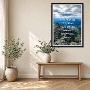Puede incluir: Una impresión de arte mural enmarcada que muestra un paisaje de montaña bajo un cielo nublado con el texto en blanco: GO INTO ALL THE WORLD, AND PREACH THE GOOD NEWS TO THE WHOLE CREATION. MARK 16:15. La impresión está en un marco negro sobre una pared clara.