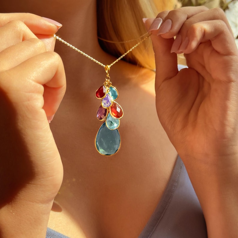 Custom birthstone mom necklace with teardrop and pear-shaped gemstones in gold bezel settings, designed to represent children’s or family birth months. This personalized necklace can feature stones like Garnet, Amethyst, Aquamarine, Diamond, Emerald, Alexandrite, Ruby, Peridot, Sapphire, Opal, Topaz, Turquoise, or custom combinations for moms, grandmas, and daughters. A meaningful Mother’s Day, birthday, or anniversary gift alternative to Jared, Pandora, or Blue Nile jewelry