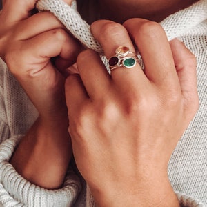 A person wearing a white sweatshirt and a silver gemstone ring set combo. Citrine ring, Garnet ring, Green Onyx ring, silver ring combo set, gold ring combo set, November birthstone ring, January birthstone ring, May birthstone ring, Scorpio jewelry