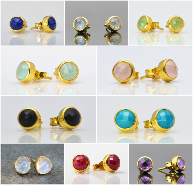 May include: A set of 10 pairs of gold stud earrings with various gemstone colors, including blue, green, pink, black, turquoise, red, and purple.