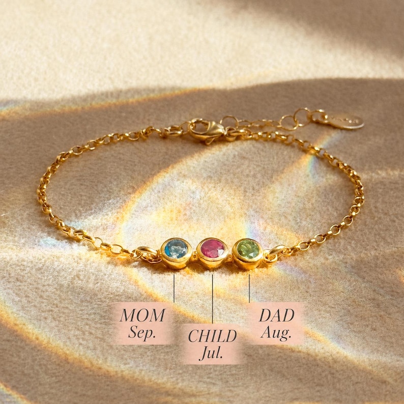 A dainty 3mm birthstone bracelet with mom, dad and child's birthstones set into a bar together.