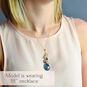 A lifestyle image of a model wearing a custom grandmother birthstone necklace featuring stacked teardrop gemstones symbolizing three generations of kids, grandkids, and grandma. Necklace shown in 18-inch length with gold vermeil chain, highlighting how the personalized family jewelry drapes naturally. A meaningful keepsake gift for grandma, mother, or new mom to celebrate family bonds and generations with a stylish, modern design celebrating family love.