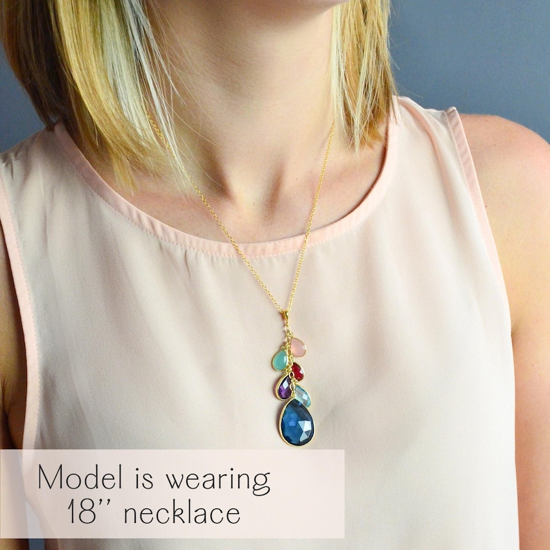 A lifestyle image of a model wearing a custom grandmother birthstone necklace featuring stacked teardrop gemstones symbolizing three generations of kids, grandkids, and grandma. Necklace shown in 18-inch length with gold vermeil chain, highlighting how the personalized family jewelry drapes naturally. A meaningful keepsake gift for grandma, mother, or new mom to celebrate family bonds and generations with a stylish, modern design celebrating family love.