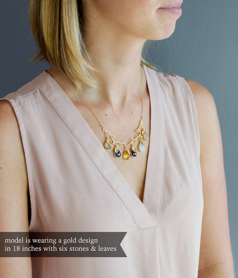 May include: A gold necklace with a branch design and six colorful gemstone drops. The necklace is 18 inches long.